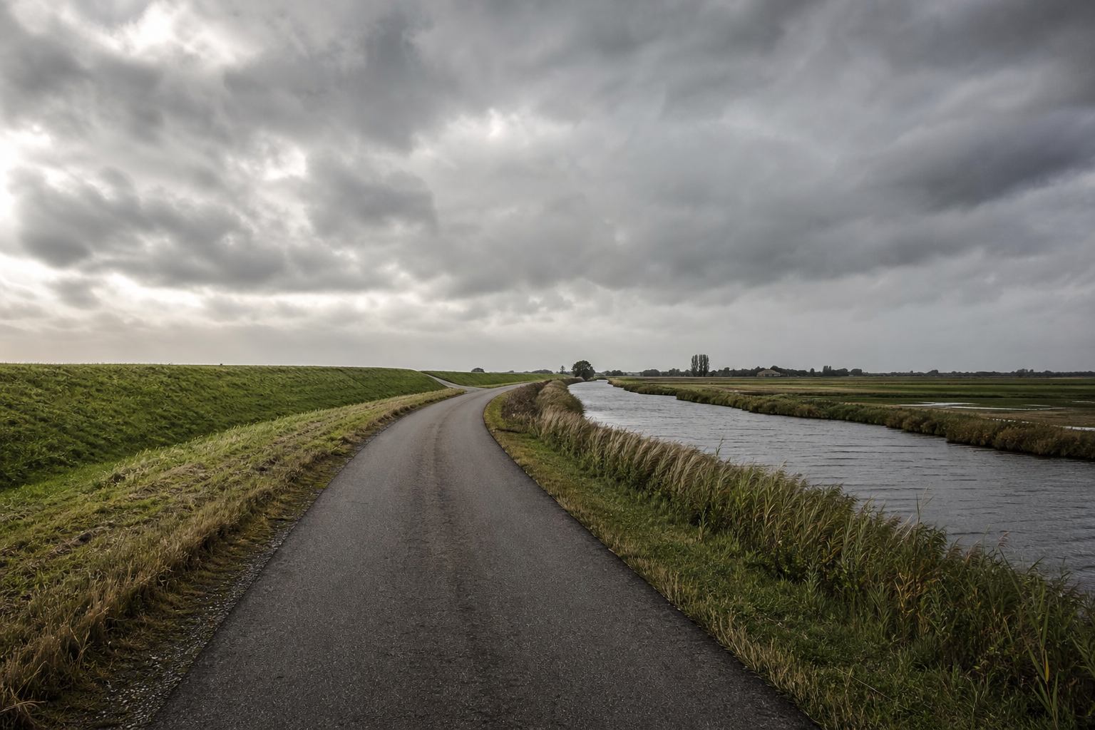 Fahrradweg entlang eines Kanals in flacher norddeutscher Landschaft